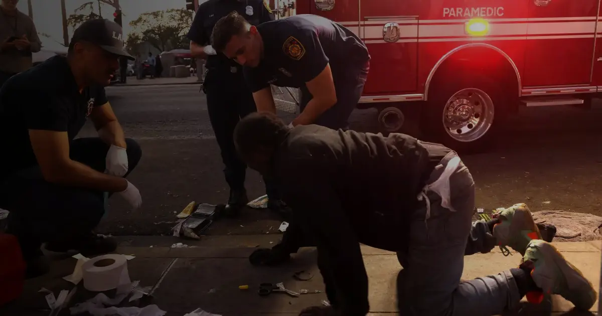 Emergency medical technicians and paramedics with Los Angeles Fire Station 11 keep an eye on a man they revived from an overdose in MacArthur Park last year.